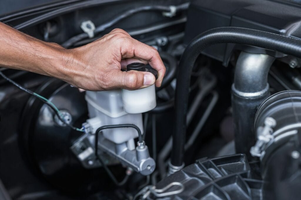 Hand technician check reservoir oil fluid level for brake system car