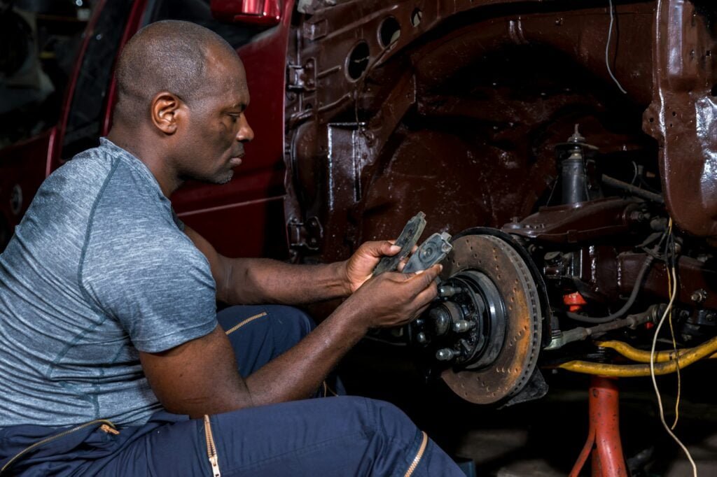 Mechanic checking and replacement of ventilated automobile brake discs.